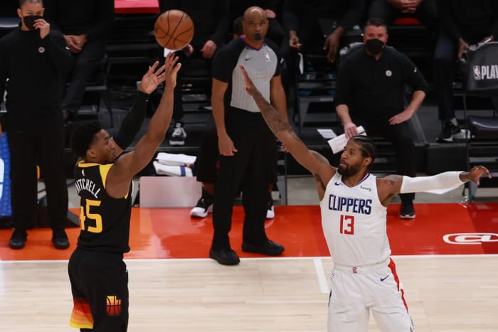 Donovan Mitchell (45) shoots a three pointer over Paul George (13)